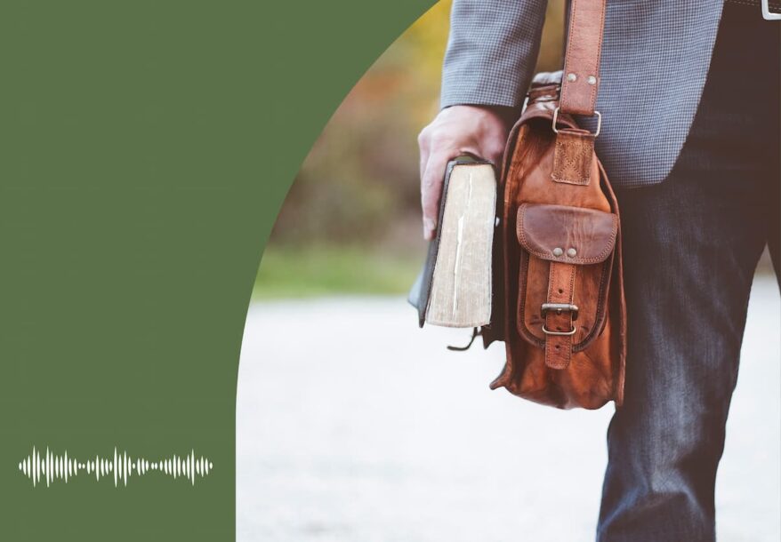 Un homme, avec un sac en bandoulière, tient une bible dans sa main.