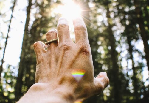 Une main tentant d'atteindre la lumière dans l'espoir d'un miracle.