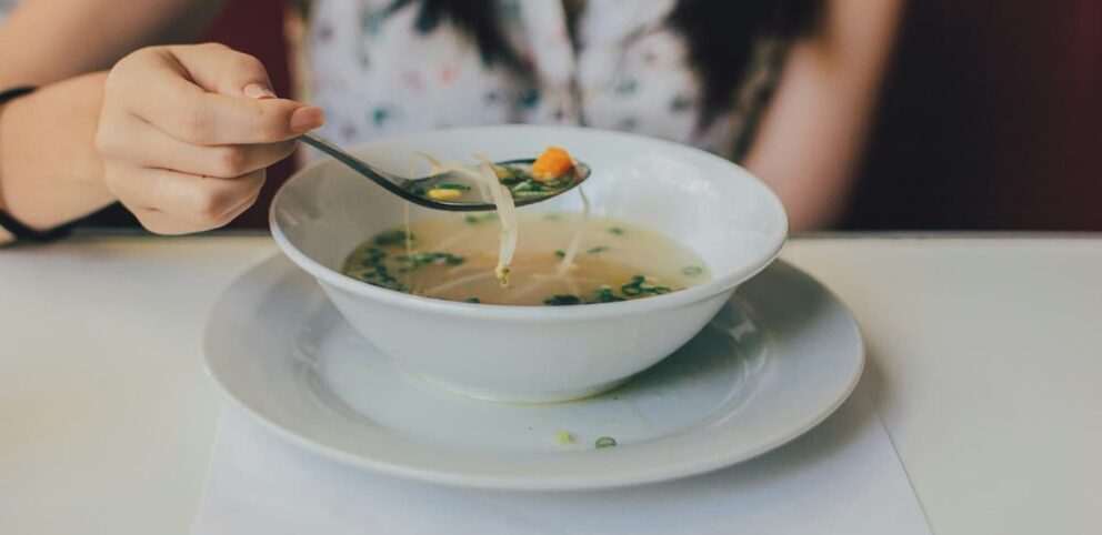 Une femme mange une soupe à l'Action de grâce.