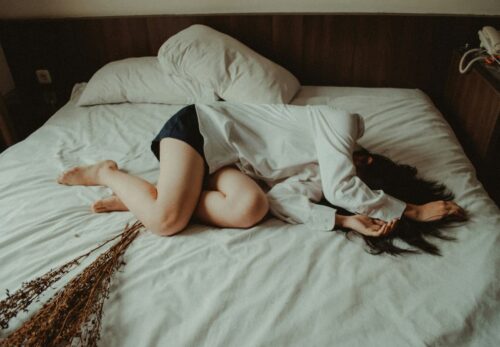 Femme dépressive couchée dans son lit.