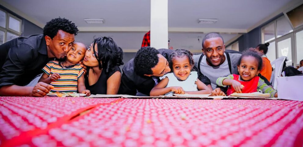 Une photo de famille avec trois papas, une maman et trois enfants.