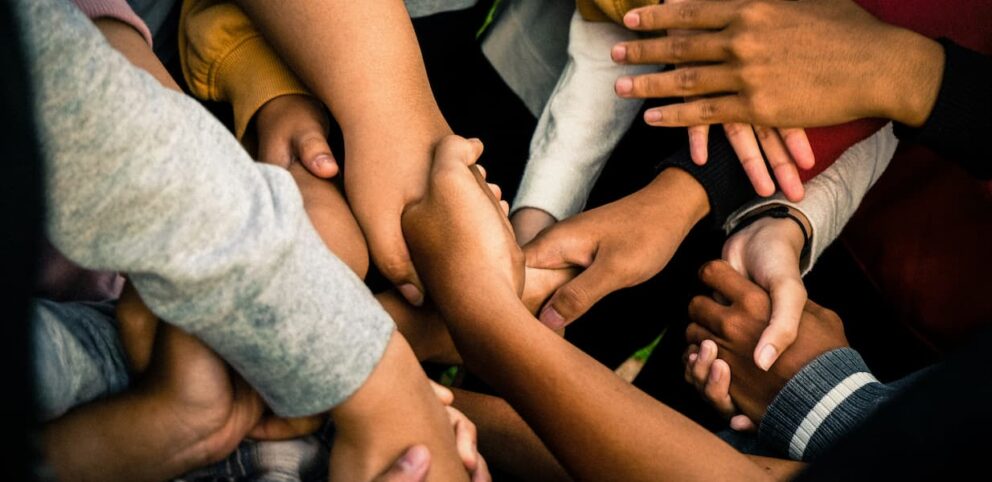 Plusieurs mains de différentes couleurs se serrant la main pour illustrer l'important d'accueillir l'autre tel qu'il est.