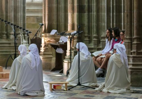 Des femmes agenouillées dans une église, en position de revendications.