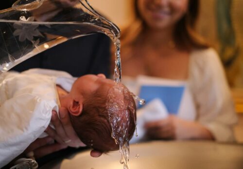 Un bébé qui se fait baptiser à l'église.