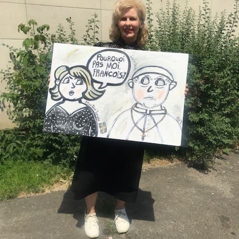 Martine tenant un poster pour revendiquer sa place dans l'Église