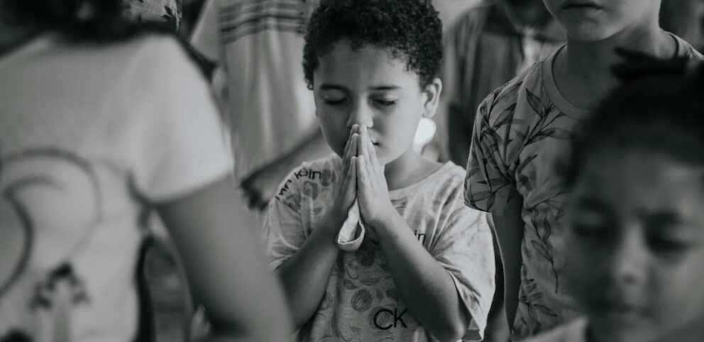 Un petit garçon en train de prier.