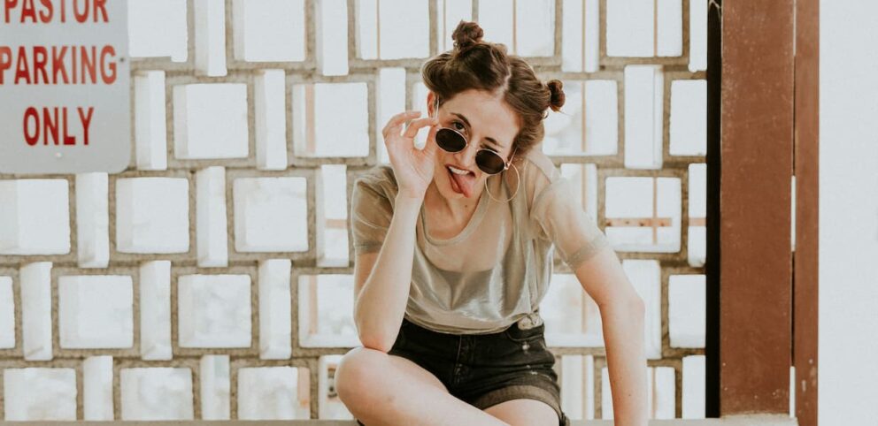 Une femme célibataire fait une grimace drôle à la caméra.