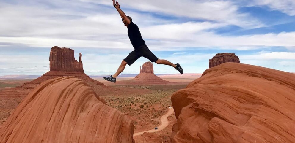 Un homme saute d'une roche à l'autre, symbolisant les transitions dans nos vies.