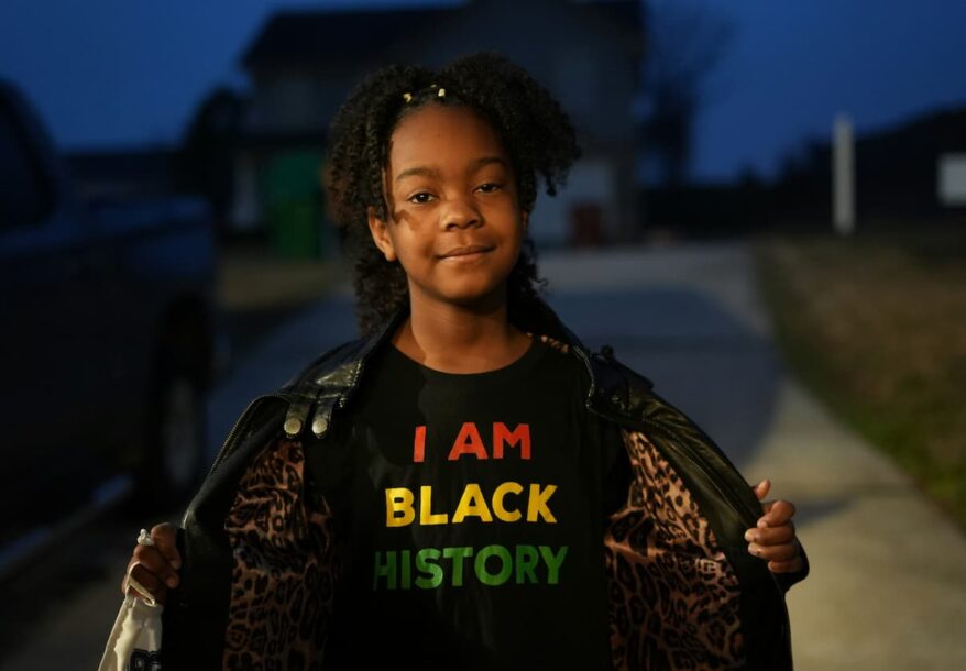 Une fille d'ascendance africaine aberrant un t-shirt indiquant qu'elle est le Mois de l'histoire des Noirs.
