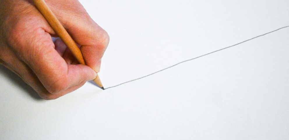 Un crayon trace une limite sur un feuille de papier.