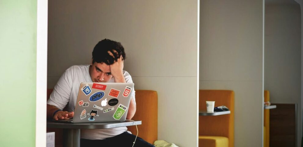 Un homme devant son ordinateur portable qui a de la difficulté à changer.